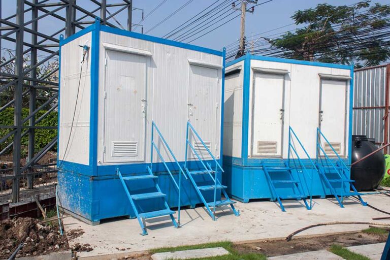 Two free standing outdoor porta potty structures